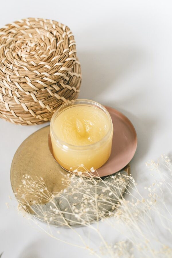 A candle sitting on top of a plate next to a basket.