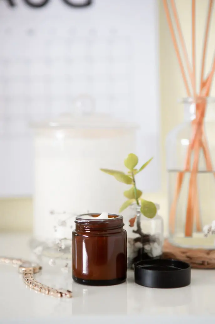 A jar of lotion sitting on top of a table.