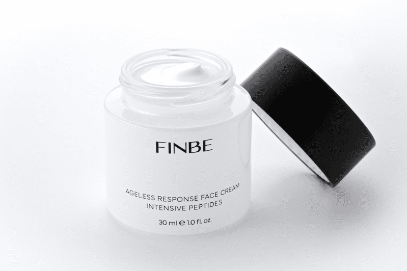 A jar of face cream with a black lid.